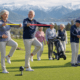Senior golfers exercising and socialising on a Swiss alpine golf course with electric trolleys.